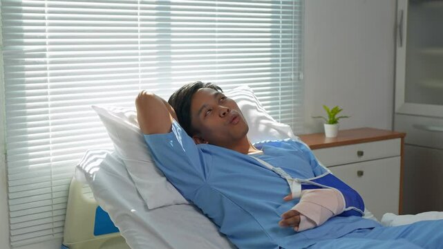 Patient recovering in hospital bed with arm in sling
