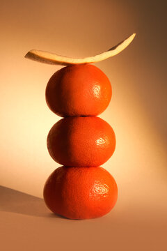 Natural still life with balancing oranges and peel in warm light. 
