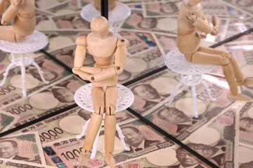 鏡に映る1万円札と木の人形