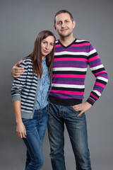 Family Values Concepts. Portrait of One Happy Young Caucasian Couple Posing Together Embraced And Having Good Time Over Gray.