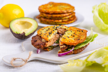 Homemade avocado bun, glutenfree flat bread with patty, lettuce, onion and cream cheese