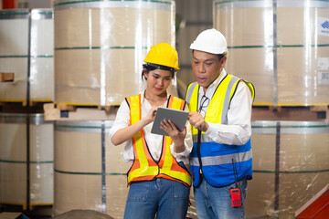 Trainee. Asian Factory worker training to  apprentice colleague on production line in Heavy Industry Manufacturing Facility. Instructor with Trainee working at factory