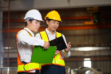Fototapeta premium Unity and teamwork. Asian team engineer worker working control sheet metal roof tile roll forming machine at metal sheet profiling factory. Industrial production
