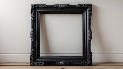 Elegant black wooden frame with intricate detailing positioned centrally against a clean white background with light hardwood flooring below.