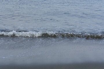 夕暮れ時の海岸に打ち寄せる波