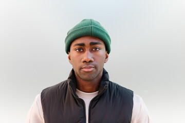 Portrait of a young black man in casual attire with green beanie
