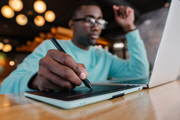 Creative professional using tablet and laptop in modern workspace