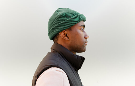 Profile of black man in green beanie and black jacket