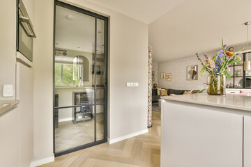 An elegantly designed modern kitchen featuring an open space concept, complemented by stylish decor and natural lighting from large windows.