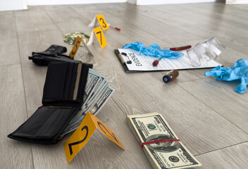 High contrast image of a crime scene with gun and markers on the floor