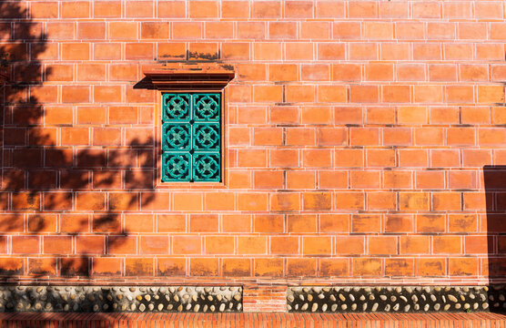 Fototapeta Traditional Chinese Red Brick Wall with Green Patterned Window
