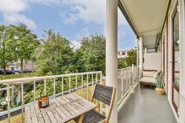 Fototapeta premium A charming balcony features wooden furniture and lush greenery, creating a serene outdoor space for relaxation and enjoyment.