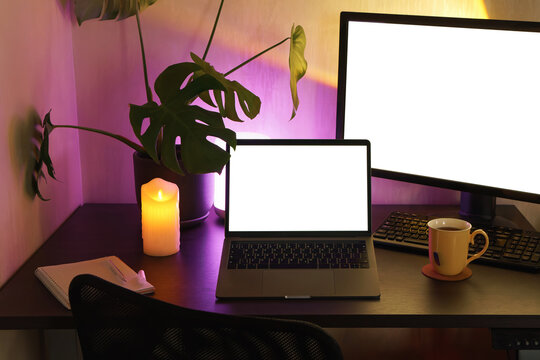 Cozy home office setup with modern laptop and ambient lighting. 