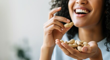 Smiling woman holding peanuts in hand, enjoying healthy snack