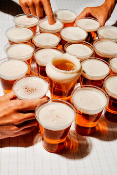 men at a table full of cups with beer