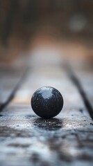 A small black stone sits atop a wooden table, simple yet striking