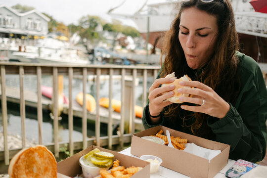 young woman eating Lobster roll in Maine 