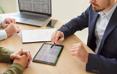 Couple of clients and financial agent or banker discussing contract terms in an office meeting....