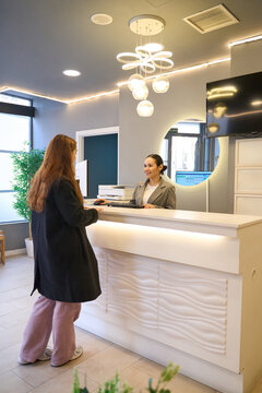 Patient interacting with receptionist at dentist's office