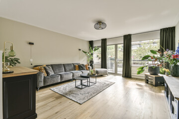 A contemporary living room featuring comfortable furniture, plants, and ample natural light, creating a warm and inviting atmosphere for relaxation.