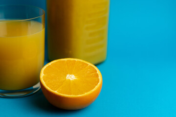 Glass of orange juice in glass close-up. Cut oranges on the table.