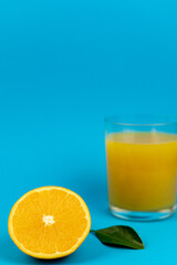 Glass of orange juice in glass close-up. Cut oranges on the table.