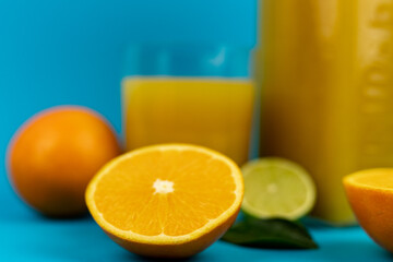 Glass of orange juice in glass close-up. Cut oranges on the table.