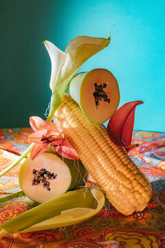 Colorful arrangement of corn and papaya against vibrant backdrop