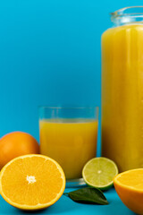 Glass of orange juice in glass close-up. Cut oranges on the table.