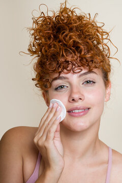 woman using cotton pad removing makeup