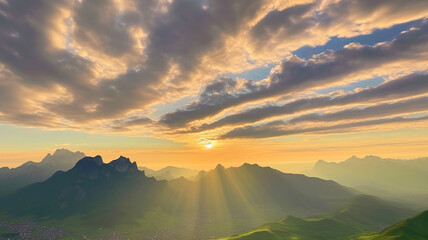 Sunset over mountain range with dramatic clouds and golden sun rays