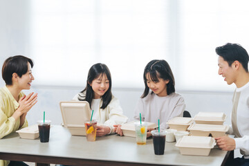 デリバリーフードを食べる女の子の家族