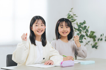 勉強しながらガッツポーズする二人の女の子