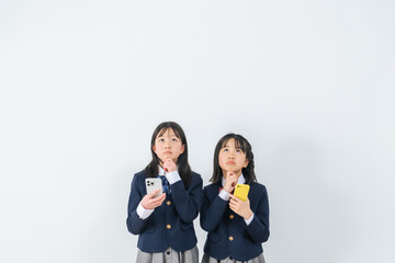 スマホを持って考える女子学生グループ