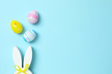 Happy Easter. Colorful eggs with bunny ears on color background, space for text or advertising