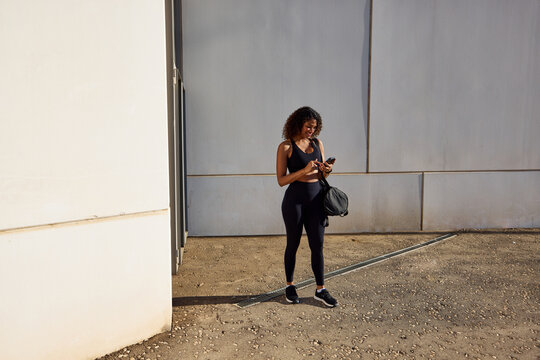 Sportswoman using mobile phone on street