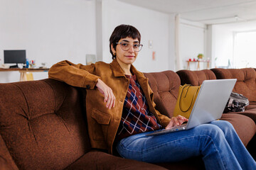 Woman working comfortably with laptop from sofa