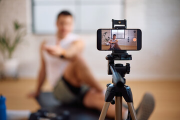 Close up of fitness instructor vlogging his workout guide.