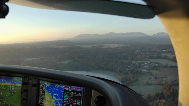 Pilot POV from Cockpit Flying Airplane over Forested Landscape at Dawn