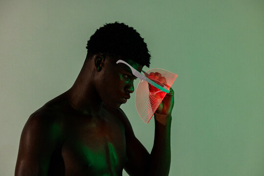 
Man doing skin care with red LED mask