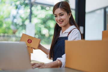 Excited young woman celebrating success while using computer laptop to see data delivery products...