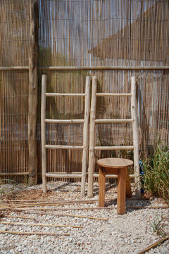 Wooden ladder and stool near the fence