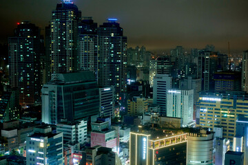 Illuminated city skyline with numerous tall buildings under a night sky. Busan, Korea
