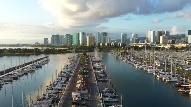 Aerial view Ala Wai Boat Harbor in Honolulu, scenic waterfront marina with sailboats, modern skyline with high-rise buildings and lush greenery