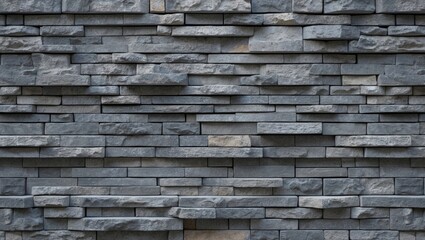 Modern stone brick wall surface in shades of gray, with varying textures and layered patterns, suitable for backgrounds in design projects.