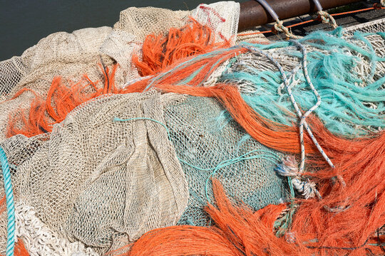 Colorful fishing nets and ropes piled on a boat deck under the sun. North Sea, Germany