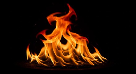 Fototapeta premium Fiery orange flames dance dramatically against a stark black background. AI Generated
