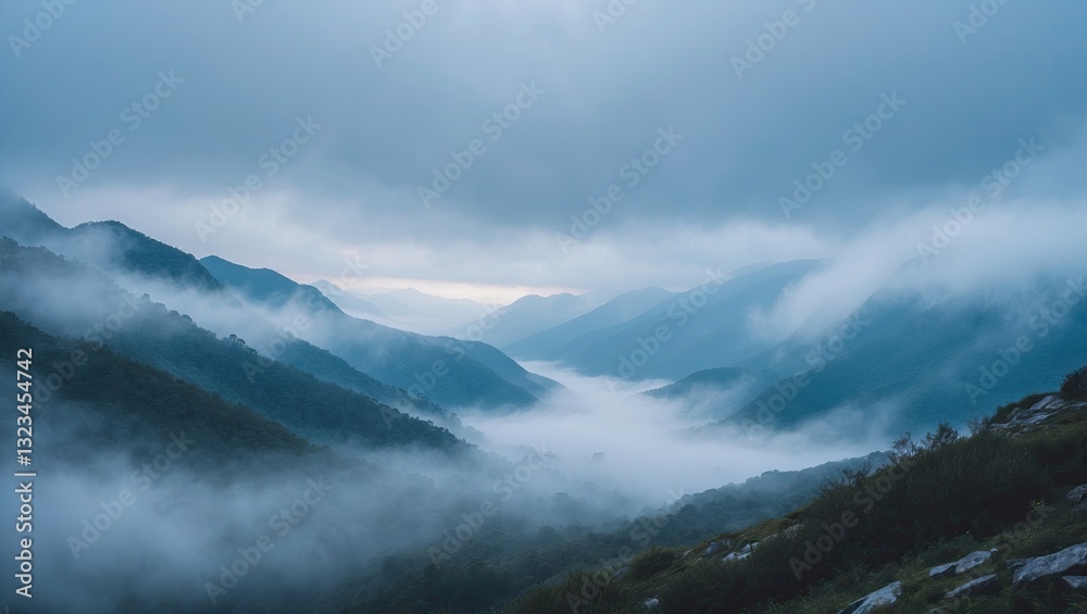 Poster misty blue mountains under a cloudy sky with soft fog rolling through a deep valley creating a seren