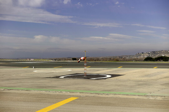 Empty airport runway with a windsock under a partly cloudy sky. Gran Canary, Spain