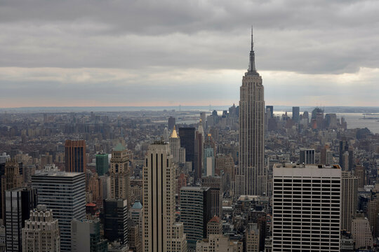 New York City skyline with Empire State Building under cloudy sky. New York, USA